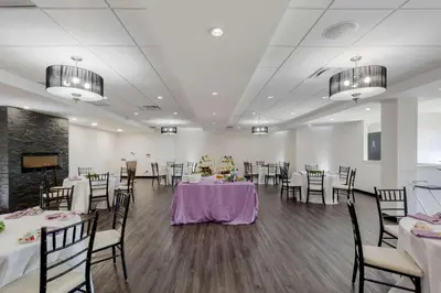a banquet room with tables and chairs and a tv at C Hotel by Carmen's, BW Premier Collection in Hamilton