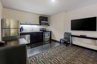 a large kitchen with a large flat screen tv at C Hotel by Carmen's, BW Premier Collection in Hamilton
