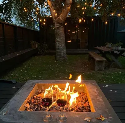 two glasses of wine are next to a fire pit at The Lakeside Prince Edward County in Wellington