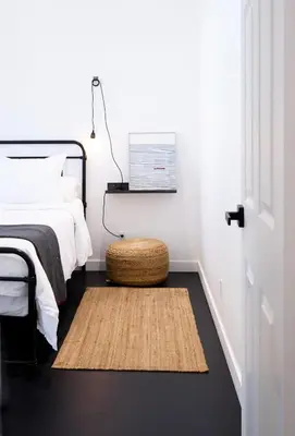 a bedroom with a bed and a rug on the floor at The Lakeside Prince Edward County in Wellington