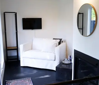 a white couch in a living room with a mirror at The Lakeside Prince Edward County in Wellington