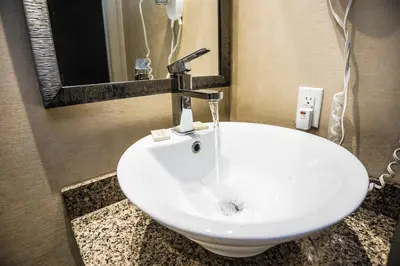 a white sink in a bathroom with a mirror at Mississauga Gate Inn in Mississauga