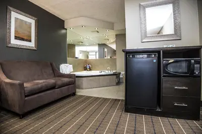 a living room with a couch and a bathroom with a tub at Mississauga Gate Inn in Mississauga