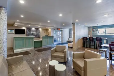 a lobby with furniture and a kitchen and a bar at Best Western Plus Woodstock Inn & Suites in Woodstock