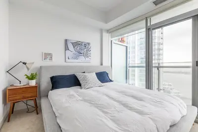 a bedroom with a large bed and a large window at Executive Corner Suite with Panoramic View in Toronto