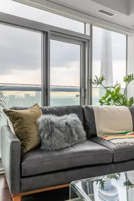 a couch in a living room with a large window at Executive Corner Suite with Panoramic View in Toronto