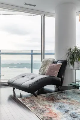 a black leather bench in a room with a large window at Executive Corner Suite with Panoramic View in Toronto