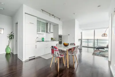 a kitchen with white cabinets and a table and chairs at Executive Corner Suite with Panoramic View in Toronto