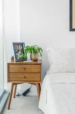 a nightstand with a picture on it next to a bed at Executive Corner Suite with Panoramic View in Toronto