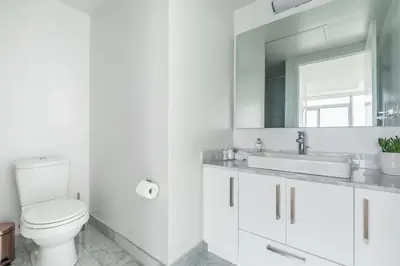 a bathroom with a toilet and a sink and a mirror at Executive Corner Suite with Panoramic View in Toronto