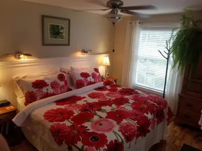 a bedroom with a bed with red flowers on it at Four Ninety Muskoka B & B in Gravenhurst