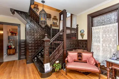 a living room with a staircase and a table at Redwood Bed and Breakfast in Niagara Falls