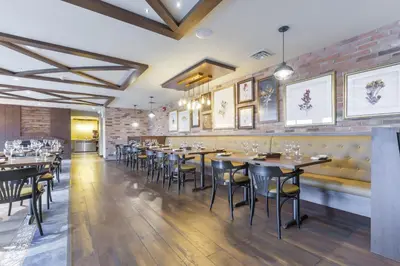 a dining room with tables and chairs and a brick wall at Northumberland Heights Wellness Retreat & Spa in Cobourg
