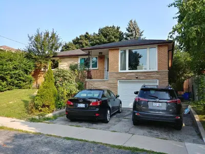 two cars parked in front of a house at Bradford Vacation in Bradford