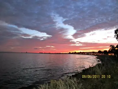 a sunset over a large body of water at Willowmere in Cobourg