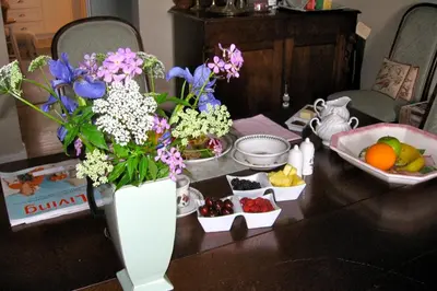 a table with a vase filled with flowers and fruit at Willowmere in Cobourg