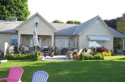 a house with two chairs in the yard at Willowmere in Cobourg