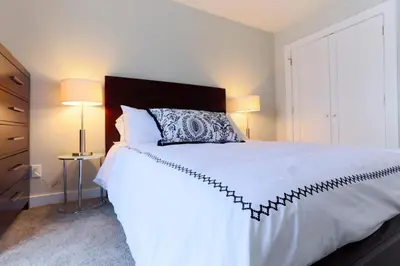 a bedroom with a white bed and two lamps at Boardwalk Homes - Executive Guest Rooms & Townhomes in Kitchener