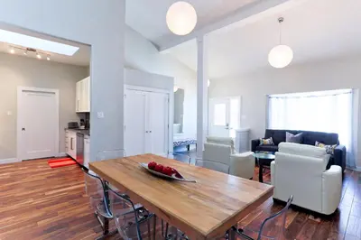 a kitchen and living room with a wooden table and chairs at Boardwalk Homes - Executive Guest Rooms & Townhomes in Kitchener
