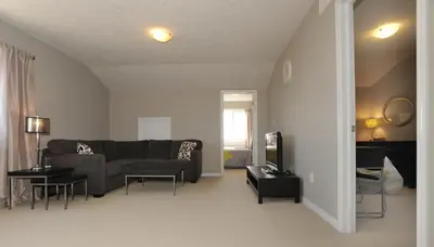 a living room with a couch and a tv at Boardwalk Homes - Vacation Homes & Executive Suites in Kitchener