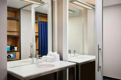 a bathroom with two sinks and a large mirror at Aloft Vaughan Mills in Vaughan