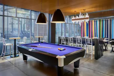 a billiard room with a pool table and chairs at Aloft Vaughan Mills in Vaughan