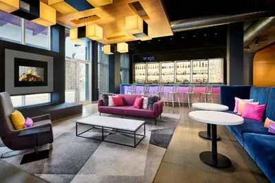 a lobby with purple couches and tables and a bar at Aloft Vaughan Mills in Vaughan