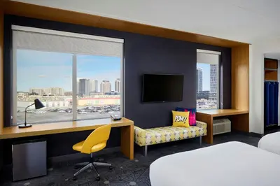 a hotel room with a bed and a desk and a window at Aloft Vaughan Mills in Vaughan