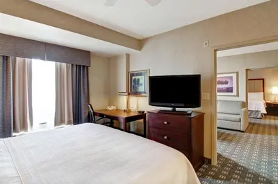 a hotel room with a bed and a flat screen tv at Homewood Suites by Hilton Toronto Oakville in Oakville