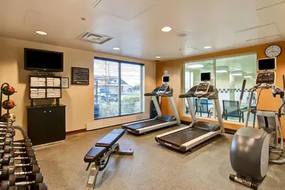 a gym with treadmills and ellipticals in a room at Hilton Garden Inn Toronto/Mississauga in Mississauga