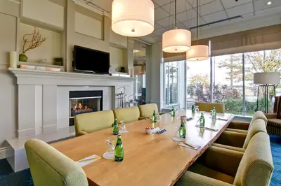 a dining room with a table and a fireplace at Hilton Garden Inn Toronto/Mississauga in Mississauga