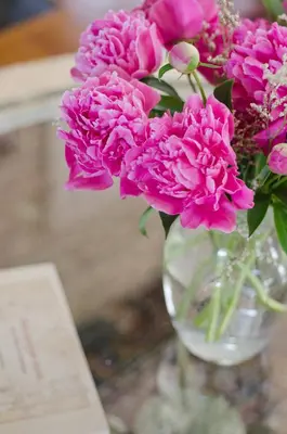 a glass vase filled with pink flowers on a table at Avery House B&B in Stratford