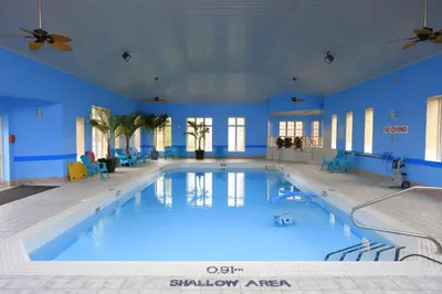 a large swimming pool with blue walls and ceilings at Fullerton Manor Inn in Niagara Falls