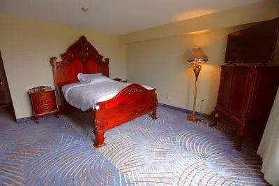 a bedroom with a large wooden bed and a lamp at Fullerton Manor Inn in Niagara Falls