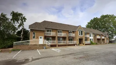 a building with a parking lot in front of it at Fullerton Manor Inn in Niagara Falls