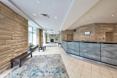a lobby with a stone wall and a bar at The Falls Hotel & Inn in Niagara Falls