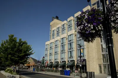 a building on a street with flowers hanging from it at The Falls Hotel & Inn in Niagara Falls