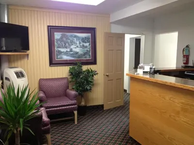 a waiting room with a chair and a desk at Milestone Motel in Collingwood