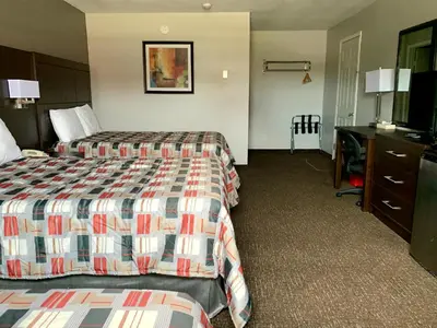 a hotel room with two beds and a desk at Milestone Motel in Collingwood