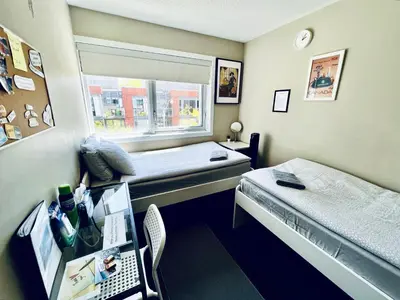 a room with two beds and a desk and a window at Home in Downtown in Toronto