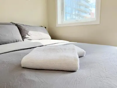 a bed with two towels sitting on top of it at Home in Downtown in Toronto