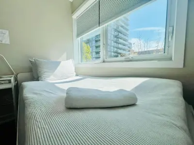 a bed with a pillow on it in front of a window at Home in Downtown in Toronto