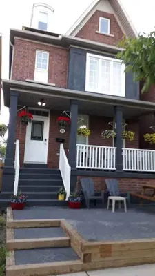 a red brick house with a porch and stairs at Village at York U in Toronto