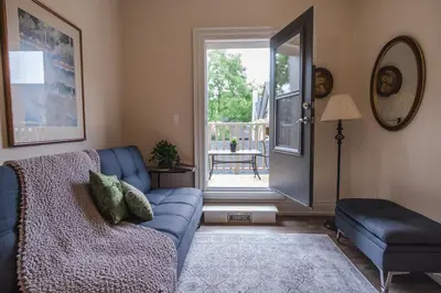 a living room with a blue couch and a sliding glass door at Evanndor in Stratford