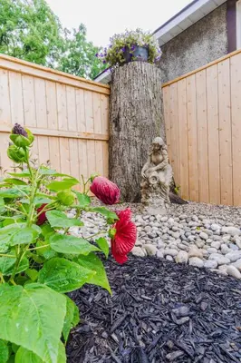 a garden with a statue next to a tree at Evanndor in Stratford