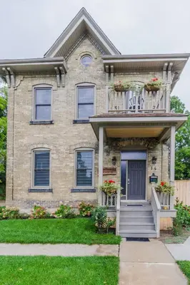 a brick house with flowers on the balcony at Evanndor in Stratford