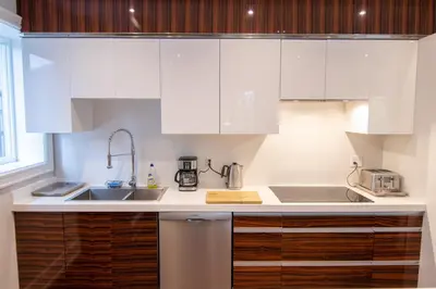a kitchen with white cabinets and a sink at Hillcrest Modern House in Toronto