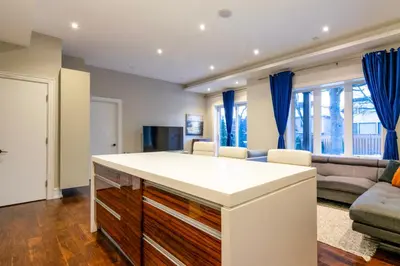 a kitchen and living room with blue curtains at Hillcrest Modern House in Toronto