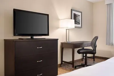 a hotel room with a television and a desk with a chair at Wyndham Garden Niagara Falls Fallsview in Niagara Falls