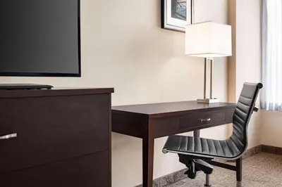 a desk with a lamp and a chair in a hotel room at Wyndham Garden Niagara Falls Fallsview in Niagara Falls
